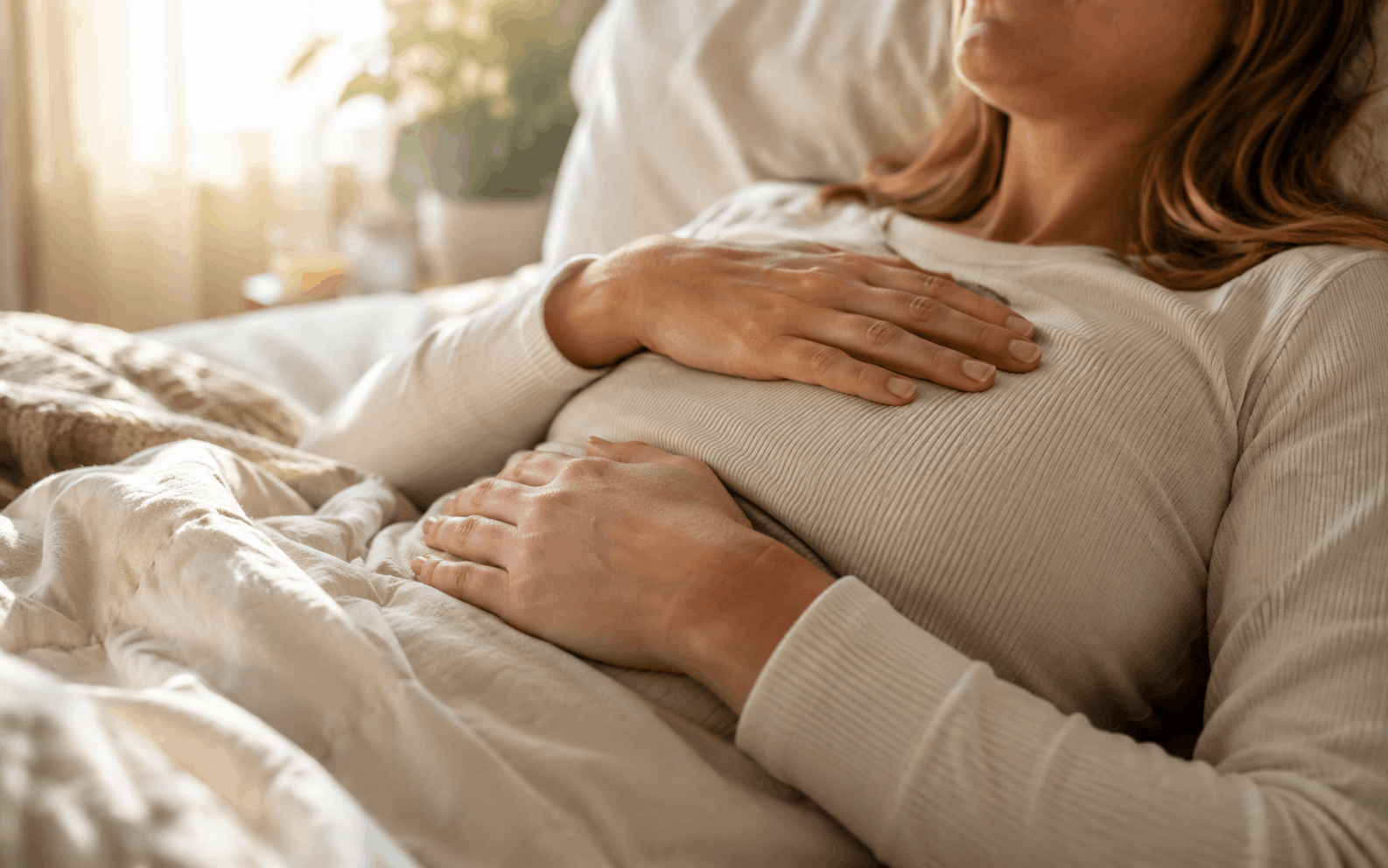 Angst am Morgen — Hände liegen sanft auf Brust und Bauch