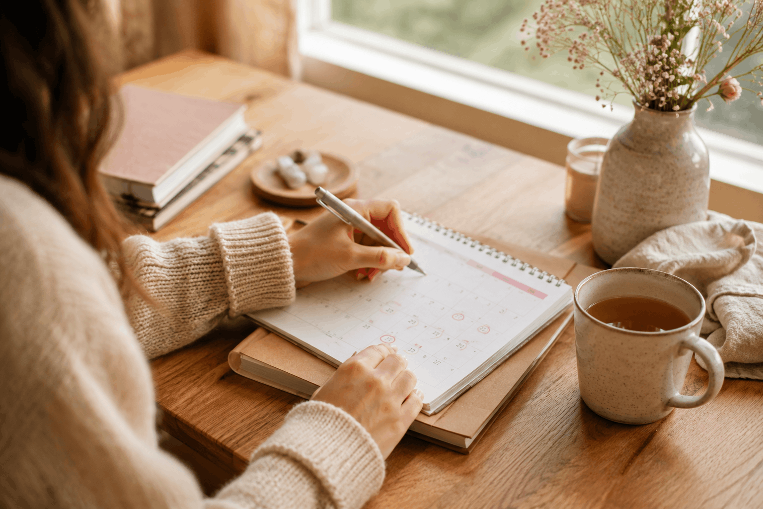 Panikattacken und Menstruationszyklus – Hände mit Kalender und ruhigen Zyklusnotizen
