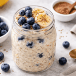 Darmfreundliche Overnight Oats mit Banane und Heidelbeeren Darmfreundliche Overnight Oats mit Banane und Heidelbeeren im Glas, gesundes Meal-Prep Frühstück mit Haferflocken und Beeren