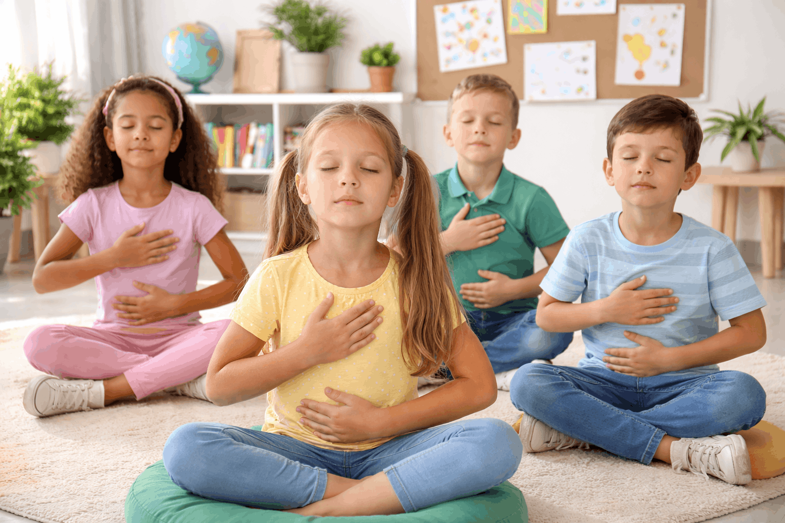 Kinder machen Atem Entspannungsübungen in der Grundschule und sitzen ruhig im Klassenzimmer mit Händen auf Bauch und Brust zur Förderung von Konzentration und innerer Ruhe