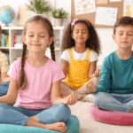 Kinder machen Entspannungsübungen in der Grundschule und sitzen ruhig im Klassenzimmer im Schneidersitz zur Förderung von Konzentration und innerer Ruhe