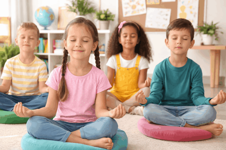Kinder machen Entspannungsübungen in der Grundschule und sitzen ruhig im Klassenzimmer im Schneidersitz zur Förderung von Konzentration und innerer Ruhe