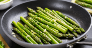 Grüner Spargel wird in einer Pfanne mit Olivenöl frisch angebraten